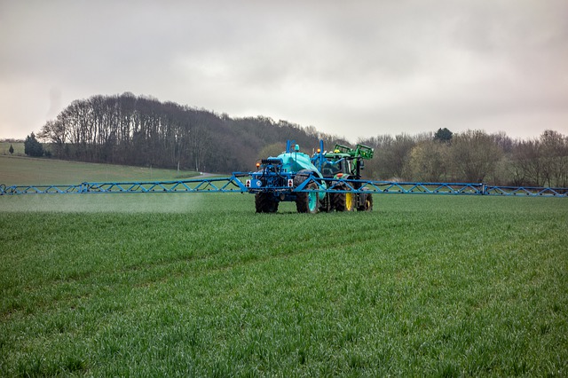 Tractor aplicando productos agrícolas a una plantación